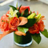 Orange roses and white lilies in a glass vase