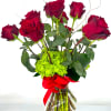 Red roses arranged in a clear glass vase with a red ribbon