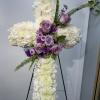 Standing floral cross with white blooms and lavender roses