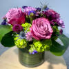 Pink roses and purple flowers arranged in a metal vase