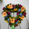 Heart-shaped floral wreath with roses, gerberas, and hydrangeas on a stand