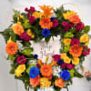 Heart-shaped floral wreath with multicolored roses and gerbera daisies