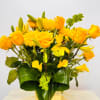 Yellow roses, lilies, and daisies in a square vase
