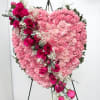Heart-shaped pink floral standing arrangement with roses and carnations