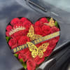 Heart-shaped box of red roses with anniversary ribbon and butterfly decorations