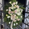 Standing spray of pale pink roses and white lilies with palm fronds