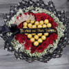 Heart-shaped bouquet of red roses and gold chocolates with a tiara