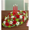 Oval table centerpiece with red roses, white daisies, and three red candles
