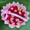 Bouquet of red and pink roses wrapped in pink paper with a ribbon