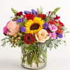 Mixed bouquet with sunflowers, roses, and chrysanthemums in a glass vase