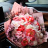 Pink and white bouquet with roses and peonies wrapped in pink paper