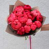 Bouquet of bright pink peonies wrapped in brown paper