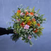 Handheld bouquet of orange and pink flowers with small white daisies