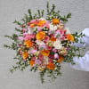 Handheld bouquet of pink, orange, and white roses with berries