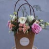 Basket arrangement with pink and white flowers and tall looping stems