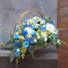 Blue and white floral arrangement in a gold hoop stand