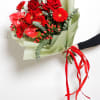 Bouquet of red roses and gerbera daisies wrapped in pale green paper