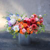 Colorful mixed flower arrangement in a metal bucket