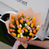 Bouquet of multicolored tulips wrapped in peach paper