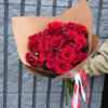 Bouquet of red roses wrapped in tan paper with red and white ribbons