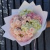 Bouquet of pale pink roses and hydrangeas wrapped in white paper