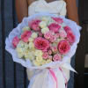 Large bouquet of pink and white roses wrapped in white paper