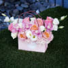 Pink and white floral arrangement in a pink gift box with handles