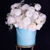 White roses and ranunculus in a blue hatbox with a pearl garland
