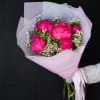 Bouquet of bright pink peonies with small white filler flowers