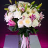 Bouquet of white and pink roses with lilies in a glass vase
