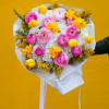 Bouquet of pink and yellow flowers wrapped in white paper