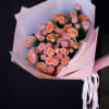 Bouquet of peach spray roses wrapped in pale pink paper