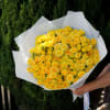 Bouquet of yellow roses wrapped in white paper