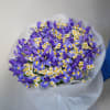 Bouquet of purple irises and small white daisies wrapped in white paper