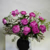 Pink peony bouquet in a black vase with white filler flowers