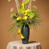 Tall floral arrangement with yellow calla lilies in a dark vase