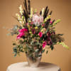 Tall floral arrangement in a textured vase with pink and white blooms