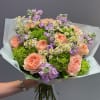 Bouquet of peach roses, purple flowers, and white daisies