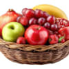 Basket of assorted fruit including apples, grapes, strawberries, and pomegranate