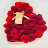 Heart-shaped bouquet of red roses with a ribbon and tag
