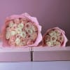 Two bouquets of pale pink and cream roses wrapped in pink paper