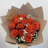 Orange roses with baby's breath in tan wrapping and a "happy birthday" topper
