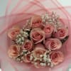 Bouquet of pink roses with white baby's breath in pink wrap