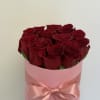 Bouquet of red roses in a pink hat box with a satin ribbon