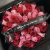 Bouquet of red and pink roses with a black ribbon reading "Will you be my girlfriend?"
