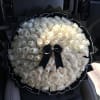 Large bouquet of white roses wrapped in black paper with a black ribbon