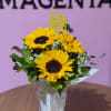 Bouquet of yellow sunflowers in a white wrapped vase