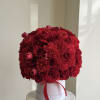 Round bouquet of red roses and carnations in a white box with a red ribbon