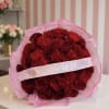 Bouquet of red roses and carnations wrapped in pink tulle