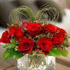 Short red rose in short vase with green spiral grass in heart